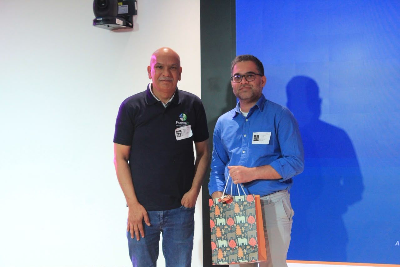 A speaker receiving a token of appreciation on stage at the inaugural session.