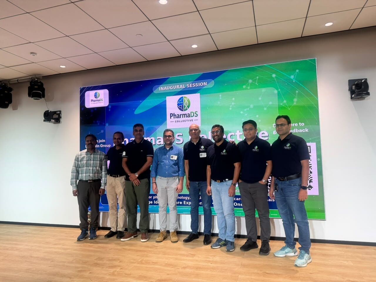 Founding members together with the session speakers and panellists, lined up on stage in front of the event screen.
